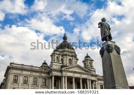 Exterior daytime stock photo of Onondaga County Courthouse in background and statute of Christopher Columbus in foreground taken in Syracuse, New York on sunny day.