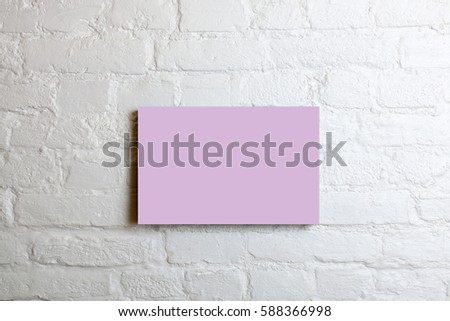 Pink blank poster in a white brick wall. Template Mock up for your content.