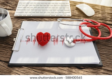 doctor workplace with stethoscope, clipboard and heart at wooden desk, health background concepts.