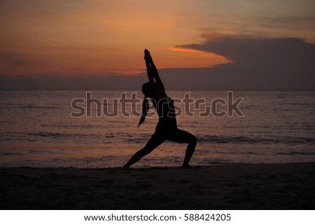 Silhouette young woman practicing yoga on the beach at sunset, Karon Beach ,Phuket ,Thailand. For background and texture.