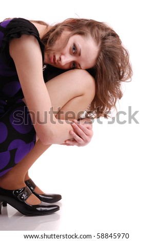 Portrait of beautiful sitting hug knees woman on white