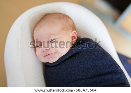 Cute adorable newborn baby wrapped in colorful blanket, sleeping and dreaming. Closeup of peaceful child, little baby girl . Family, Birth, new life. Swaddling as method for calm child Royalty-Free Stock Photo #588475604