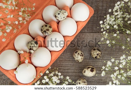 Carton of organic white eggs with easter decor on wooden board. Easter decor. Top view.