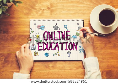 Online Education text with a person holding a pen on a wooden desk