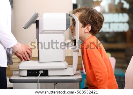eye examination, Optometrist in exam room with young boy 
