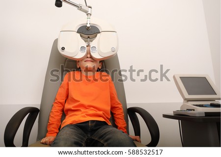 eye examination, Optometrist in exam room with young boy 
