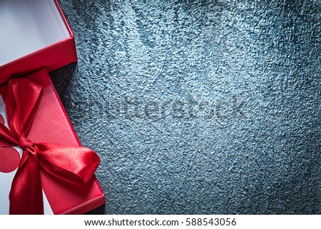 Opened present box with red ribbon on black background holidays concept.