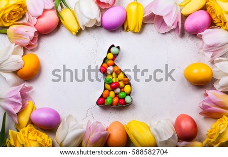 Colorful Easter eggs and spring flowers  on old background. Easter concept with copy space. Flat lay