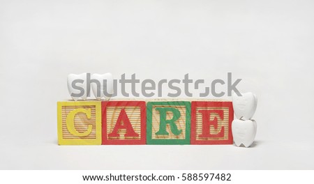  Tooth model in happy emotion and colorful toy boxes read ' CARE ' 2