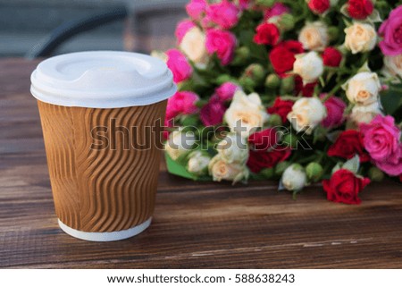 Bunch of  fresh elegant roses and cup of coffee on wooden background
