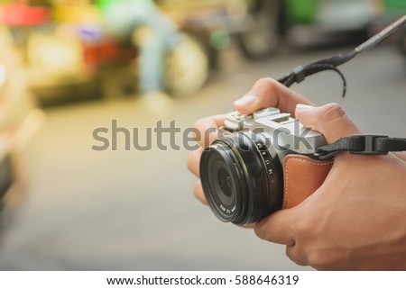 Tourist hold digital camera (mirrorless camera) ready for take a photo Royalty-Free Stock Photo #588646319