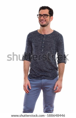 Thoughtful happy young handsome man smiling and standing while wearing eyeglasses