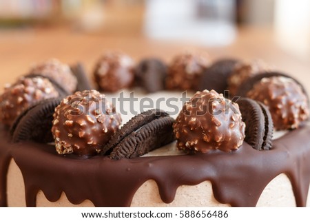 Handmade chocolate cake on wooden background. Chocolate cake decorated with chocolate, candy and cookies.