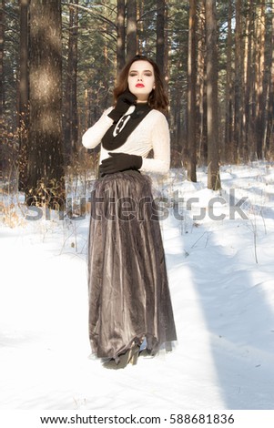 girl in a long skirt in the winter forest