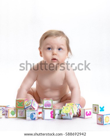 First Steps baby. Little boy playing with blocks with letters and pictures. Isolated on white.