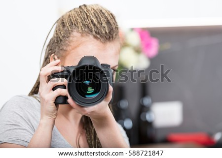 passionate woman is a photographer in her kitchen, with her faithful camera and a laptop she's taking and checking her photographs to get better every day