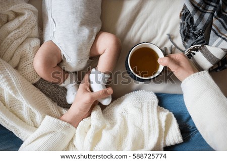 Unrecognizable mother with newborn baby son lying on bed Royalty-Free Stock Photo #588725774