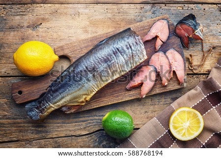 Smoked dog-salmon with a lime and lemon on a wooden table Royalty-Free Stock Photo #588768194