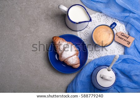 Breakfast with coffee cup, croissant and note good morning. Top view. Copy space