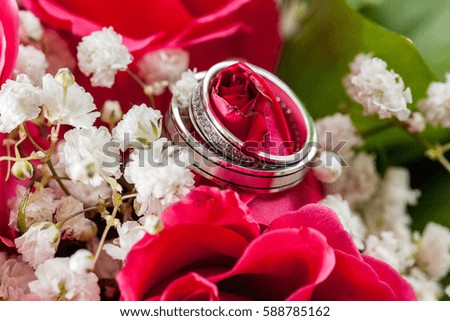 Close up view of golden rings at wedding decoration ceremony on red roses