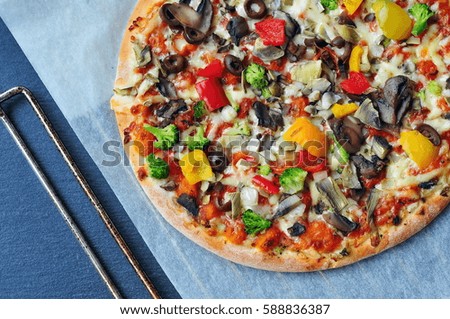 Vegetarian pizza on a dark background with mushrooms, cheese and peppers