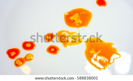 big and small oil spots with air bubbles stay in chaotic picture. colorful orange golden yellow different size oil with light circles inside against white background. abstract picture made of food oil