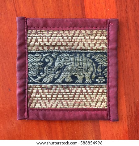 A square art  plate for glass with Thai elephant picture on wood table background