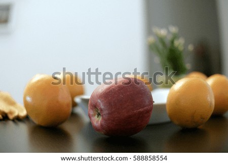 Orange fruit and apple on wooden table background