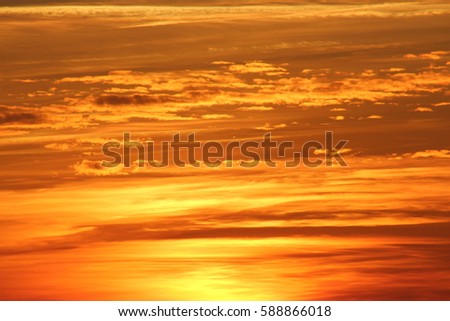 Intensive orange colored sky at sunset, warm summer evening in France at the beach, clouds, background, width, space 