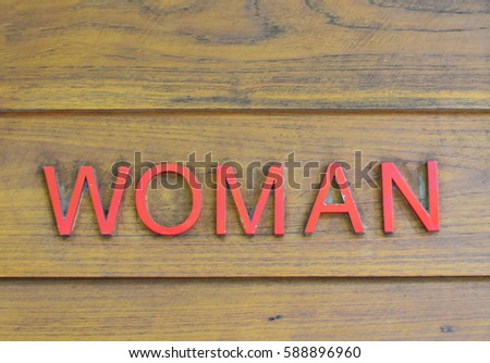 Public restroom sign for female on wooden wall