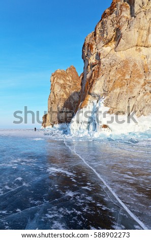 Lake Baikal in winter. Olkhon Island. Photographer walking on the ice that would photograph the rocks of cape Sagan Khushun