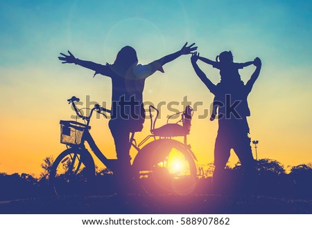 Happy Family,father,mother and daughter with bicycle at sunset