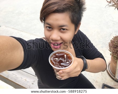 Woman taking a selfie with iced coffee