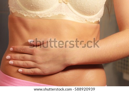 Skincare and bodycare concept. Part body slim fit female belly, perfect abdomen muscles. Woman in pink shorts. Diet aspects.