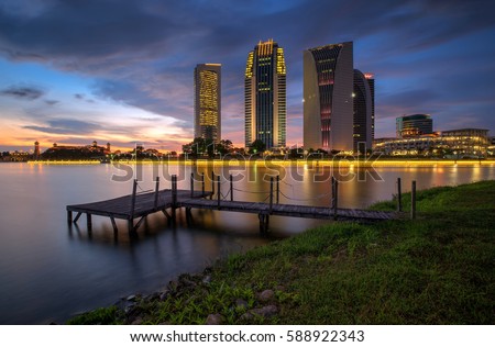 Secenery landscape of modern buildings by the lakeside with old wooden jetty in Putrajaya, Malaysia during sunset