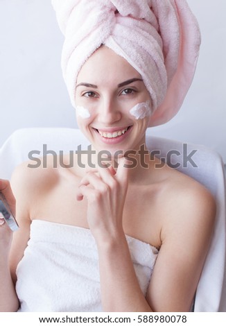 calm beautiful girl with a towel on her head posing on white background