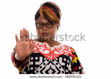 Studio shot of fat black African woman giving stop hand sign
