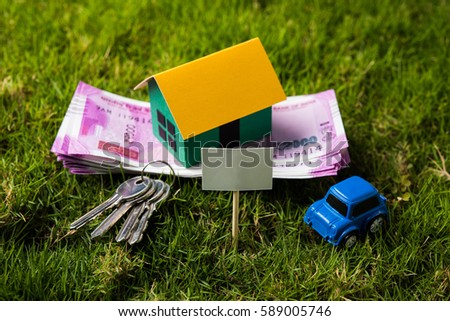 Indian Real Estate, Automobile Finance business concept showing 3D model house and Toy car with keys, paper currency notes and Calculator. Selective focus