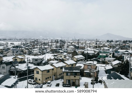 Countryside village along railway covered by snow, Tohoku, Japan.
