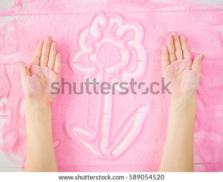 Children's hands make a decorative pattern on the sand. Educational activities for children.
