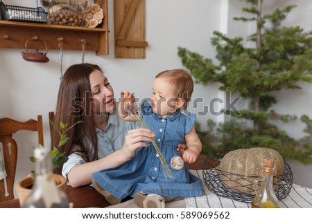 Caucasian mother and daughter are preparing in the kitchen, the girl is smelling lavender, lifestyle style