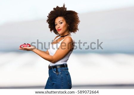 young black woman holding a red car