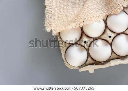 Cardboard egg rack with eggs on gray background. Top view.  Rural still life, natural organic healthy food with free space