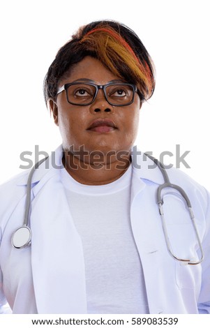 Face of fat black African woman doctor thinking while wearing eyeglasses