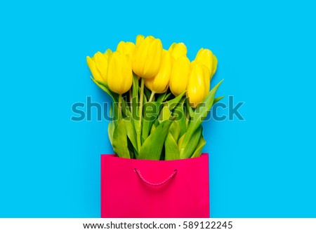 bunch of yellow tulips in cool shopping bag on the wonderful blue background