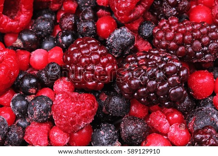 Frozen mixed berries as background. Blueberries,raspberries black berries and currant mulberry texture pattern