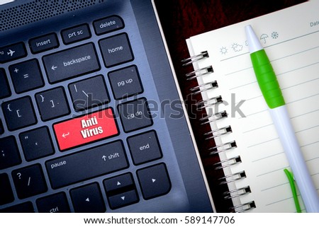 Laptop keyboard with red key with text "Anti Virus", notebook and a pen, top view