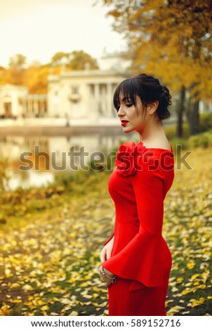 Bright contrasting portrait lady. Waist High portrait of a woman. Young lady walking in the forest. Portrait of a girl with long dark hair. Photo of a woman in rich tones. Red lips. Long hair. 
