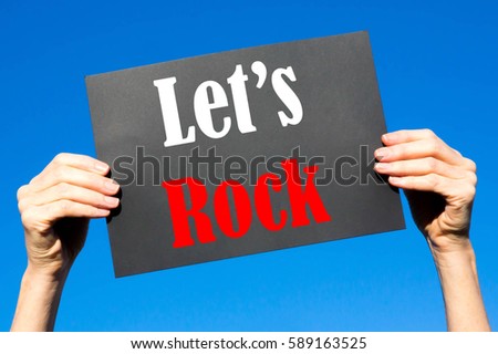 Black card placard with the concept of Let's Rock against a clear blue sky background