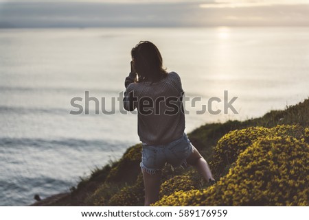 Clouds sky and sunlight sunset on horizon ocean. Silhouette person tourist traveler photographer making pictures seascape on photo camera on background sunrise. Relax view, mock up evening nature